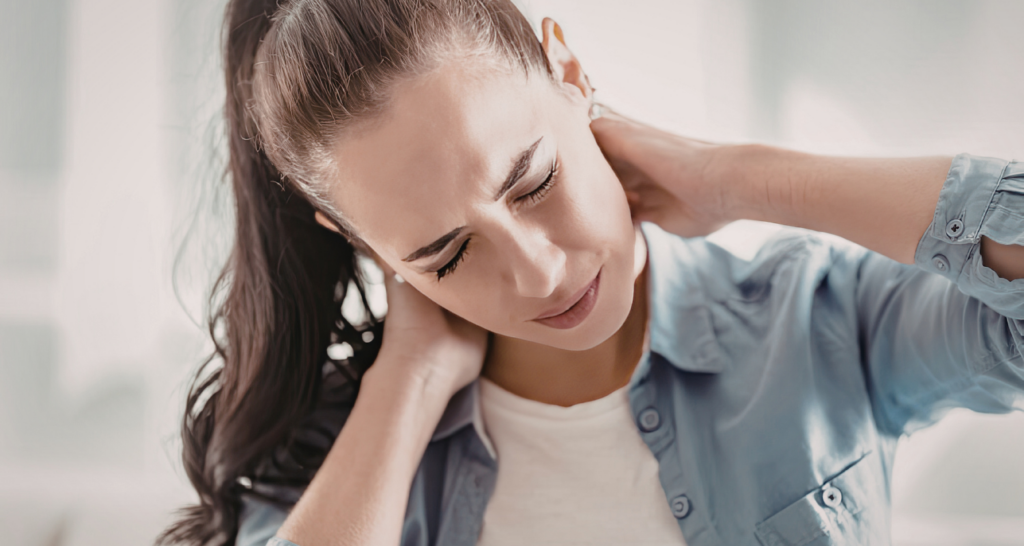 Ragazza che si tocca il collo in segno di dolore