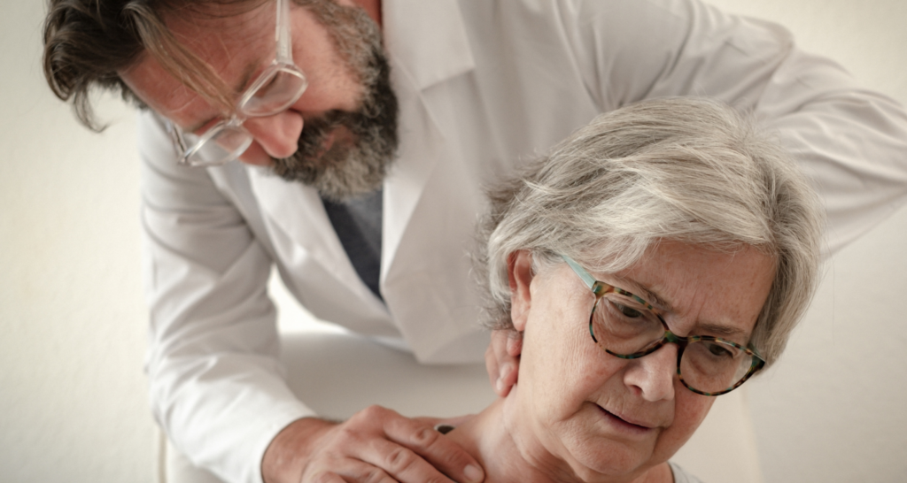 Medico che guarda il collo di una signora anziana